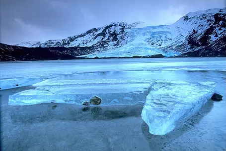 An icy lake with mountains in the background.