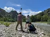Three students in the field by a river using GNSS to survey in a GCP.