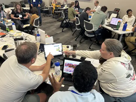 Workshop participants working on data processing in a classroom.