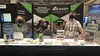 Two people from the Executive office staff Standing behind a table at the NAGT booth at AGU in 2021