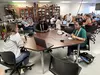 A group of students sitting around a table talking and laughing