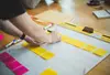 person putting sticky notes on a poster board