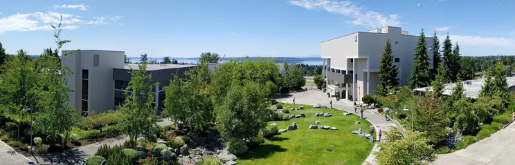 A panorama of a green and tree-filled college campus.
