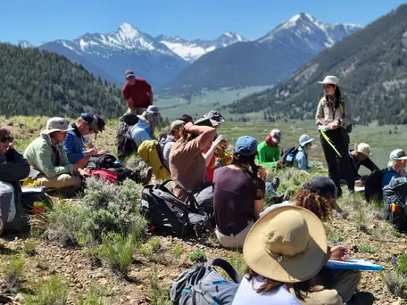 students in the field with mountains in the background