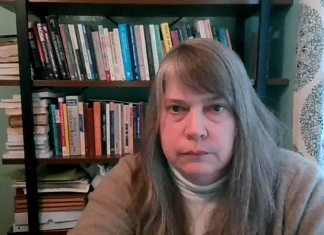Profile photo of Kerry Vachta in front of book case.
