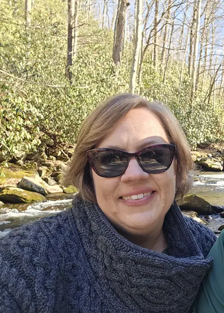 Picture of person sitting alongside a river